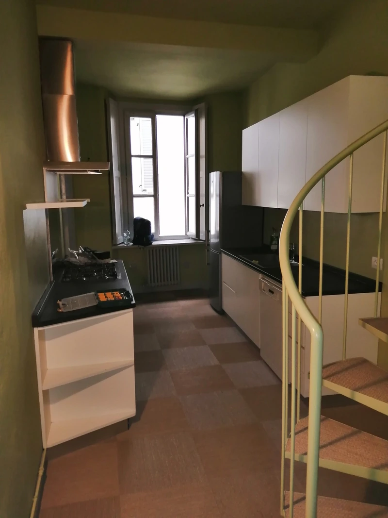 Cucina con pareti verdi e scala a chiocciola